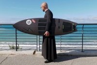 Un giovane prete, il mare e la tavola da surf