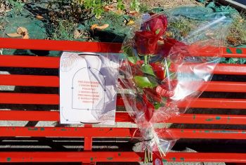 Un mazzo di fiori sulla panchina rossa di Piazza Brin